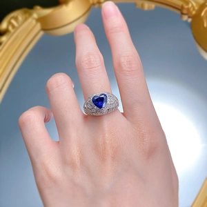 Close-up of heart-cut blue sapphire ring with pavé diamonds on elegant silver band