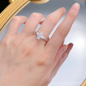 Detail of silver clover ring with sparkling zircon stone on a woman's finger