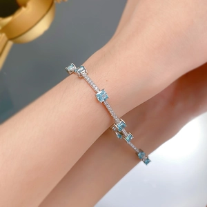 Détail d'un bracelet en argent S925 avec pierres aigue-marine au poignet féminin