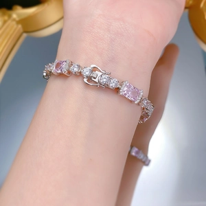 Détail du bracelet élégant en argent S925 avec pierre rose sur le poignet d'une femme