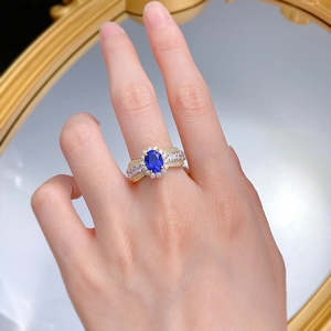 Detailed macro of a 925 silver lace-edged ring with oval blue sapphire and white diamonds