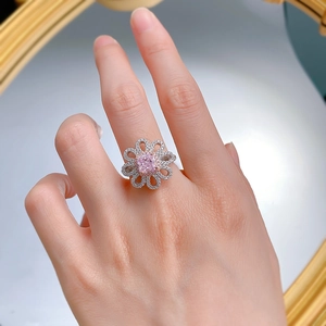 Macro de la bague en argent S925 avec un motif de fleur rose et des pétales scintillants