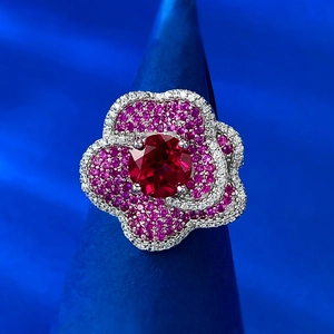 Exquisite S925 silver flower ring with red gemstone and pink pavé crystals on blue stand