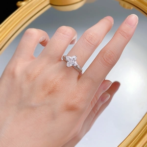 Détail macro d'une bague en argent 925 fleur à quatre pétales portée au doigt