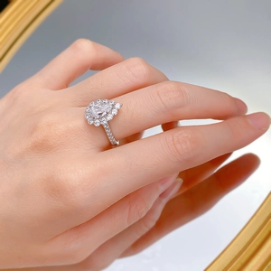 Vue macro d'une bague en argent goutte 6x9mm avec halo de diamants sur miroir