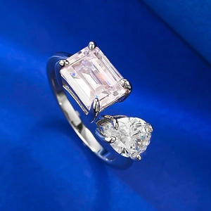 Macro detail of silver open ring featuring emerald-cut and pear-cut clear gemstones