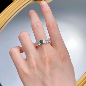 Detail showing an elegant silver ring with oval green gemstone and row of zircons