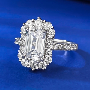 Elegant emerald cut S925 sterling silver ring with halo diamonds on a blue background