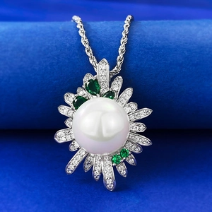 Macro detail of S925 silver sunflower pendant with 12mm pearl and emerald stones