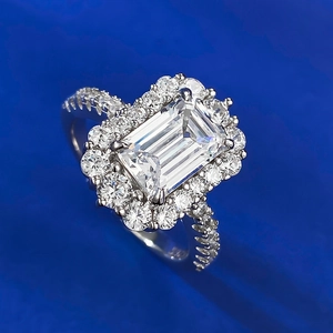 Macro shot of 925 sterling silver ring with emerald cut center stone and halo diamonds