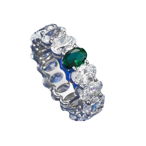 Oval cut eternity ring with green gemstone center in silver-tone metal finish