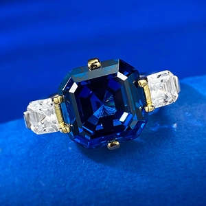 Macro view of emerald cut sapphire with side zircons on a gold-plated ring band