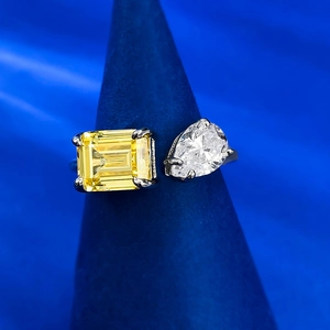 Detailed shot of open ring featuring yellow emerald-cut and white pear-cut gemstones