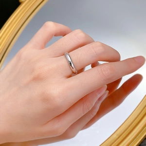 Gros plan d'une bague minimaliste en argent S925 poli au doigt avec un reflet de miroir