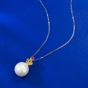 Elegant 11mm pearl pendant necklace with gold crown detail and ruby on blue background