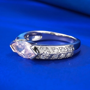 Macro shot of marquise-cut pink gemstone ring with diamond accents on silver band
