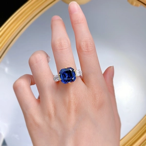 Close-up of royal blue Asscher cut sapphire ring with gold plating on model finger