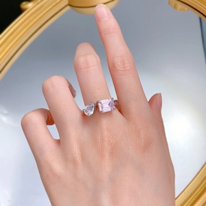 Detail of silver open ring with teardrop clear zircon and rectangular pink gemstone