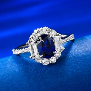 Macro detail of oval blue sapphire ring with baguette and round diamond halo