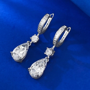 Macro detail of pear-cut pink zircon drop earrings with S925 silver stamp on dark fabric