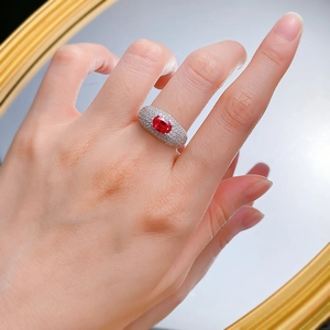 Elegant wide ring with oval red ruby and pave-set white crystals on finger
