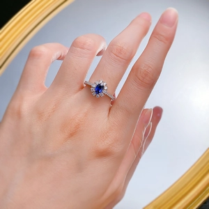 Bague en argent S925 avec saphir ovale et halo de diamants portée avec reflet miroir