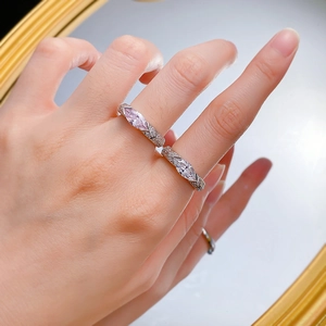 Macro detail of S925 silver marquise pink and white diamond rings on a model's hand