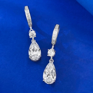 Macro detail of pear-cut pink crystal drop earrings with sparkling pavé hoop setting