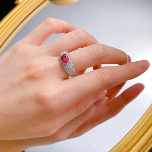Close-up of model wearing oval ruby ring with micro-pave cubic zirconia on wide silver band