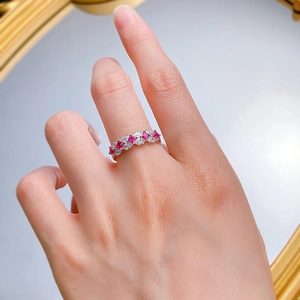 Detail of silver eternity ring with alternating red ruby and white zircon stones