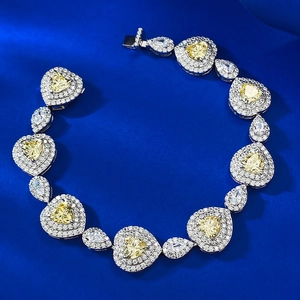 Close-up of heart-shaped yellow gemstone bracelet on a luxury blue silk background