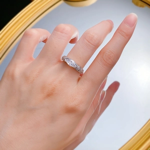 Macro shot of silver ring featuring a marquise-cut pink stone on a model's finger