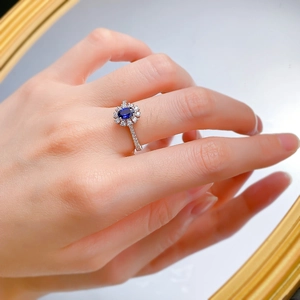 Gros plan d'une bague en argent S925 avec saphir ovale et halo de diamants floral