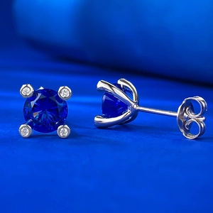 Macro detail of 1ct blue sapphire earrings with vintage four-prong silver setting