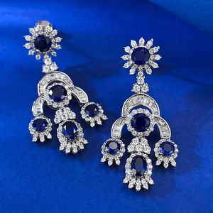 Luxuriöse S925 Silber Vintage-Ohrringe mit blauen Edelsteinen auf blauem Satinhintergrund