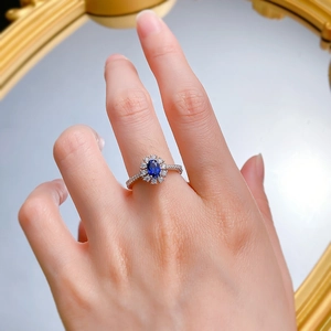Gros plan d'une bague en argent S925 avec saphir ovale et halo de diamants brillants