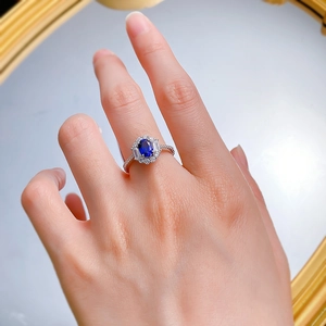 Macro detail of S925 silver ring featuring an oval blue sapphire and halo diamond setting