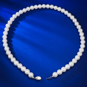 Macro shot of 8mm round pearl necklace showing S925 silver clasp detail on blue fabric