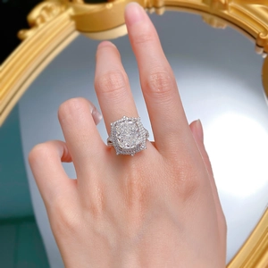 Macro detail of cushion-cut halo engagement ring with multi-row pave diamond band on finger