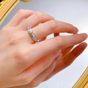 Detailed view of marquise pink gemstone silver ring with pavé stones on a model's hand