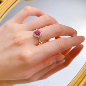 Macro detail of an oval sapphire ring with multi-layer diamond halo on a model's hand