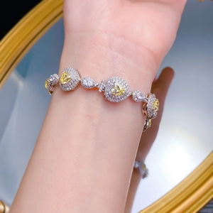 Macro shot of S925 silver bracelet featuring heart-shaped yellow diamonds and white gems