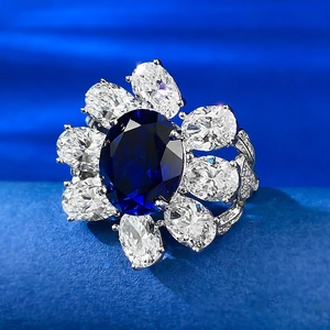 Macro shot of oval blue sapphire center stone with dazzling floral halo on silver ring