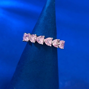 Macro shot of S925 silver ring featuring heart-cut pink zircon stones on a blue stand