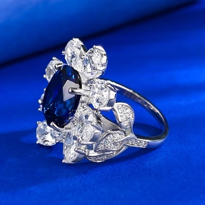 Detailed side view of an oval blue sapphire ring with marquise cut cluster petals