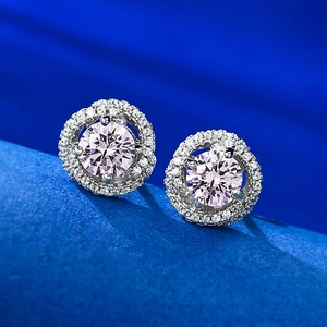 Vue macro de boucles d'oreilles halo avec pierres rondes roses et montures en argent