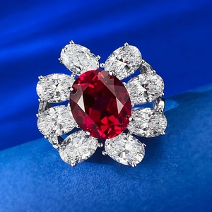 Detailed view of an oval red gemstone flower ring with sparkling white petals