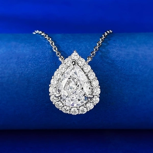 Macro shot of 8x10mm pear-cut white gemstone pendant with halo diamonds on a silver chain