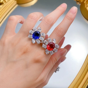 Detail of s925 silver rings featuring oval red and blue gemstones with zircon petals