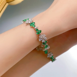 Close-up of S925 silver flower bracelet with heart-shaped green gems and white stones